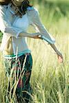Femme jeune hippie à pied à travers champs, écouter de la musique