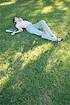 Businesswoman lying in grass
