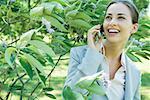 Businesswoman using cell phone outdoors, smiling