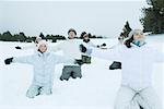Group kneeling in snow with arms out and eyes closed