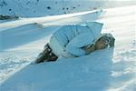 Girl lying curled up on snow