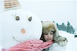 Teen girl hugging snowman