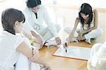 Group therapy, adults sitting in circle, one drawing on whiteboard