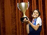 Boy with blue ribbon and trophy cup smiling