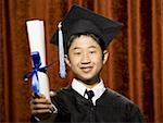 Boy graduate with mortar board and diploma smiling with braces