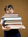 Boy holding pile of textbooks