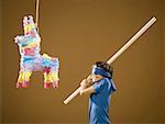 Blindfolded boy with stick and pinata