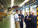 Man Talking to Workers in Car Factory