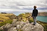 Mann, stehend auf Felsen, Banks Peninsula, Neuseeland
