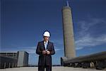 Homme d'affaires à l'extérieur de l'usine avec un agenda électronique