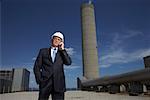 Businessman Outside Factory with Cellular Phone