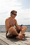 Man Using Cell Phone on Dock