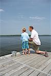 Father and Son Fishing from Dock