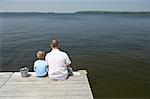 Father and Son Fishing from Dock
