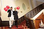 Couple with heart shaped balloons on a stairway
