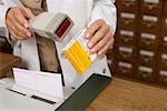 Female pharmacist scanning drug at cash register