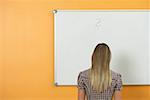 A woman in front of a white board