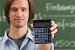 Un homme tient une calculatrice à la main