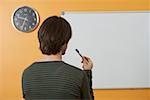 A man is standing in front of a white magnet board