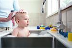 Baby Bathing in Kitchen Sink