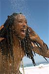 Homme sous la douche à la plage