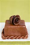 A cake decorated with a chocolate rose
