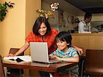 Boy and Mother with Homework in Restaurant