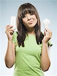 Woman with fluorescent and incandescent light bulbs