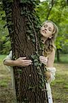 Woman hugging tree with eyes closed