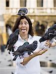Woman with pigeons and eyes crossed with tongue out
