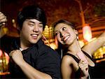 Couple listening to mp3 player outdoors dancing and smiling