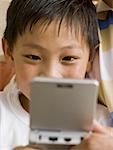 Closeup of boy with handheld electronic device