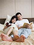 Couple in bed snuggling and reading