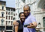 Couple s'enlaçant et prendre un autoportrait avec caméra