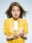 Woman holding fluorescent lightbulb