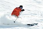 Mature skier on ski slope, smiling, blurred motion