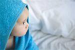 Baby wrapped in towel, looking away