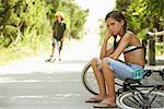Petite fille assise sur le vélo à la recherche en colère