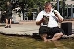 Businessman Reading Newspaper in Wading Pool