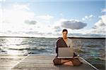 Woman Using Laptop on Dock