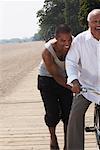 Son Pushing Father on Bicycle