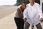 Son Pushing Father on Bicycle