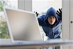 A burglar looking through a glass door