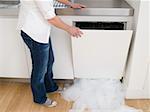 Woman opening a leaking dishwasher