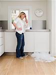 Woman looking at leaking dishwasher