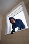 A burglar climbing through a window