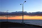 Lamp posts in front of sunset sky