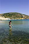 Young woman at the beach wading in water