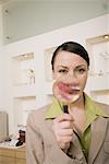 Woman with magnifying glass on mouth with tongue sticking out