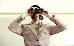 Woman with binoculars standing on counter in eyeglass store